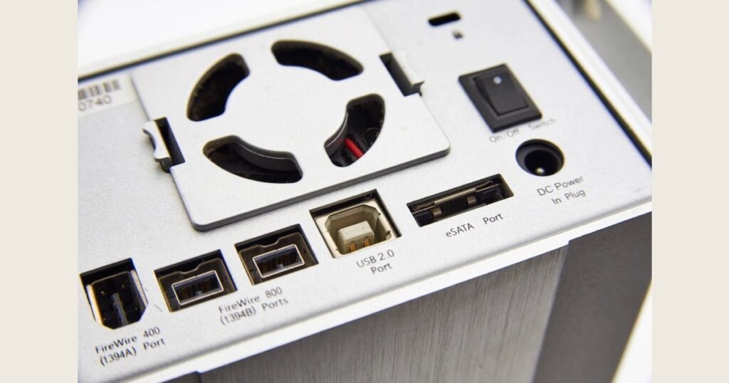 Rear panel of a drive enclosure with a cooling fan and connection ports
