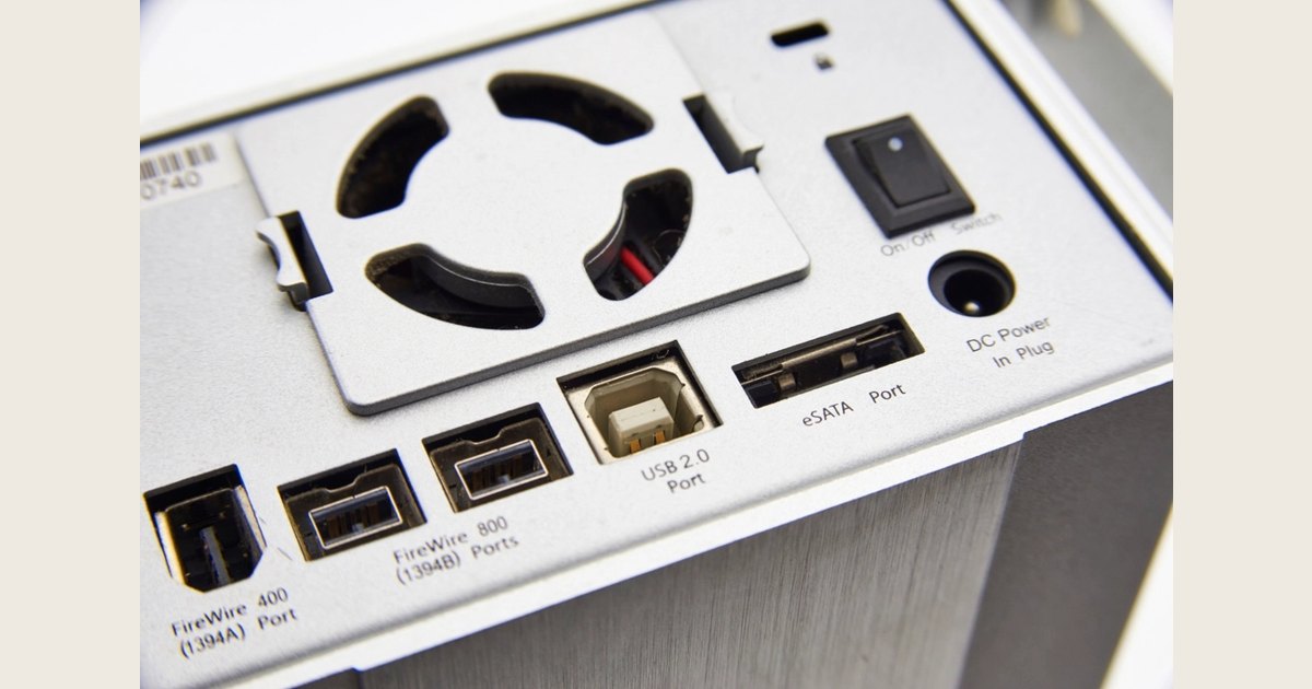 Rear panel of a drive enclosure with a cooling fan and connection ports