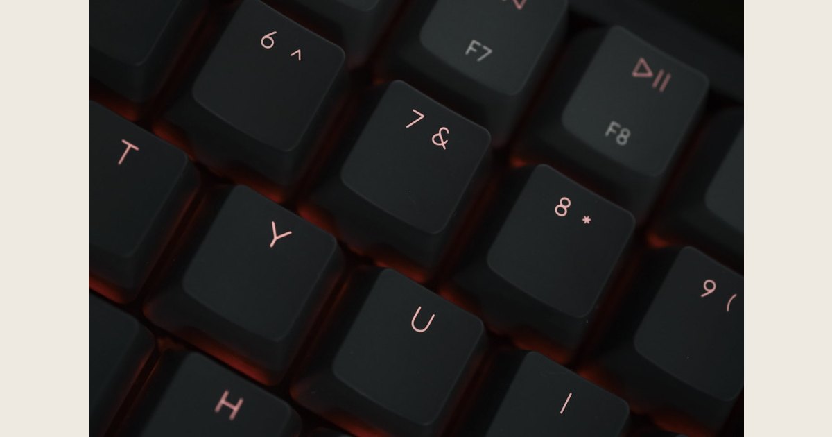 Close-up of a mechanical keyboard with rows of individual labeled keycaps